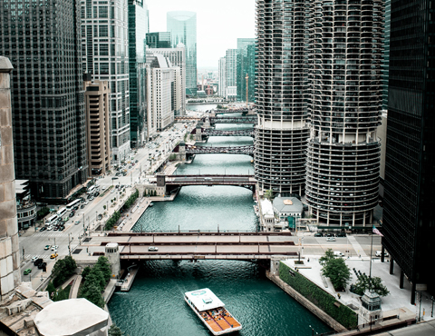 Cityscape with a river running down the middle with buildings on both sides and multiple bridges connecting each side of the city