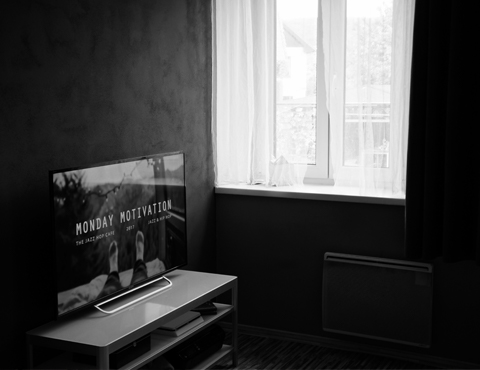 Dark hotel room with a TV on showing a motivational picture