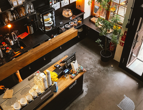 Overhead view of a brightly lit coffee shop counter and work areas